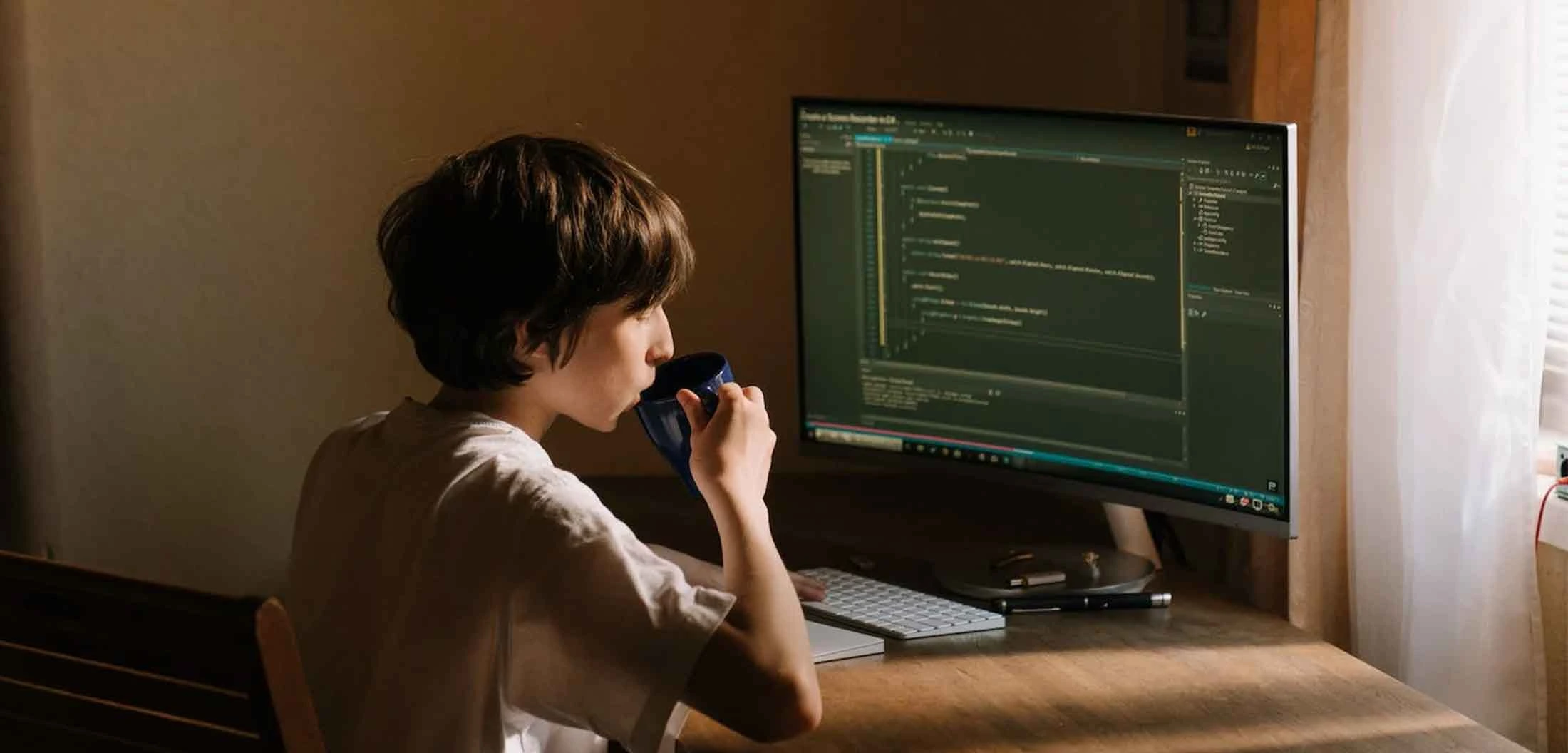 Tester looking into the screen with a coffee mug in hand